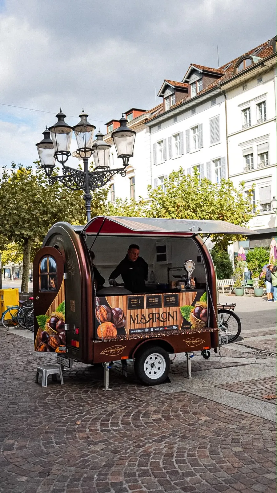 Der neue Marronistand geöffnet, Verkäufer an der Pfanne