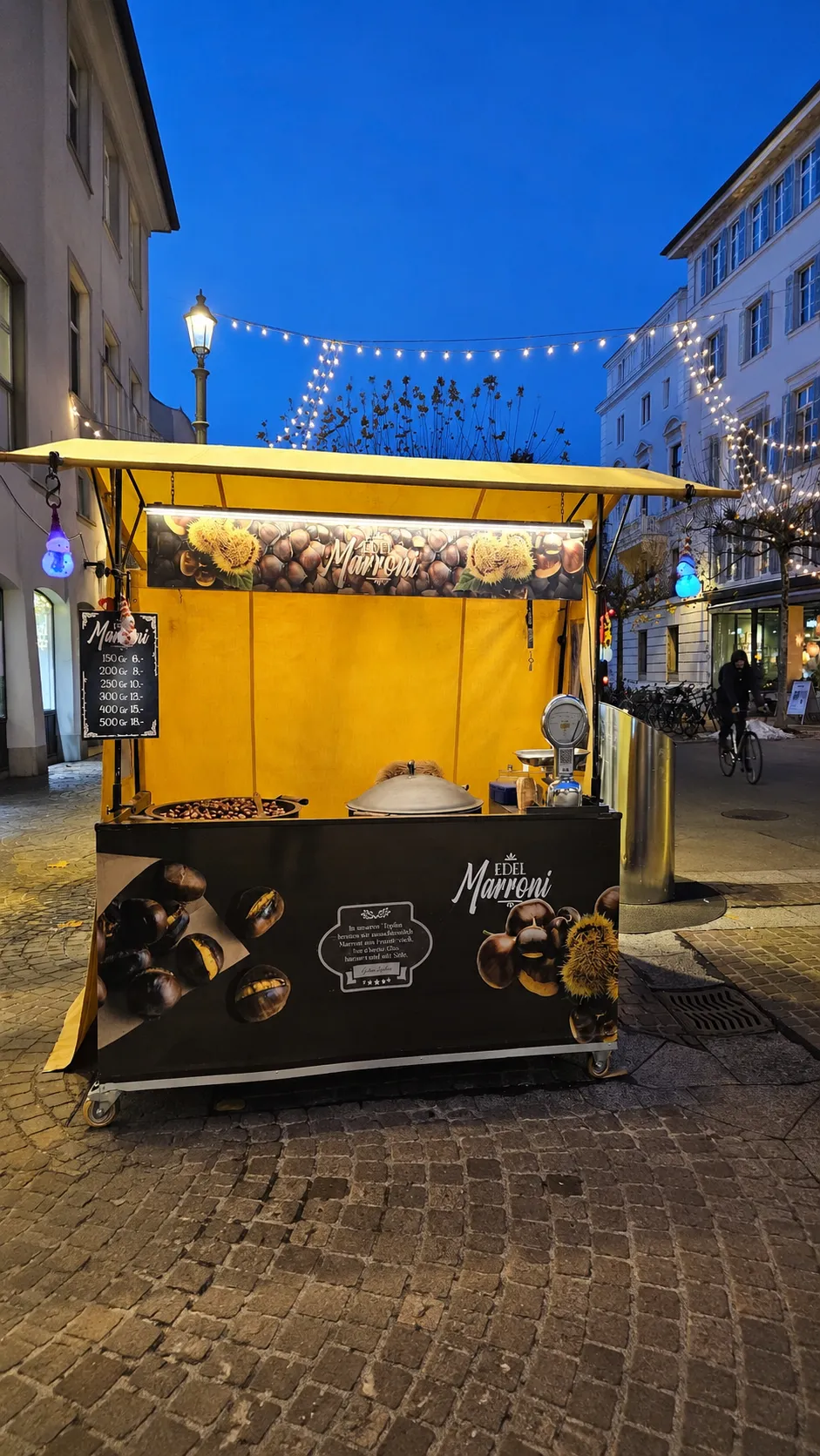 Marronistand am Abend mit Lichterketten